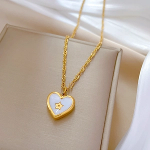 Macro shot of a gold heart pendant with shell inlay and star on a velvet jewelry box