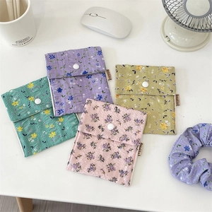 Flat lay of floral cotton quilted sanitary napkin storage bags in four soft pastel colors