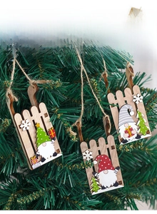 Detailed view of three DIY wooden Christmas gnome sled ornaments hanging on a tree