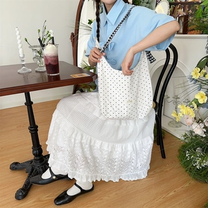 Detailed view of the polka dot canvas tote bag in a vintage French style cafe setting