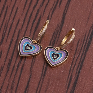 Close-up of heart earrings with colorful enamel and diamond-set hooks on wood background