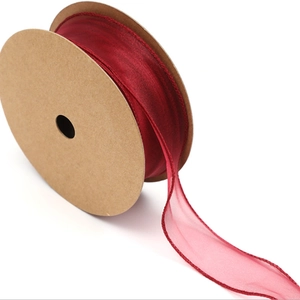 Macro shot of wine red chiffon ribbon roll with elegant wavy texture for gift wrapping