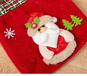 Detail of red Christmas gift bag with Santa Claus, Xmas tree and snowflake appliques