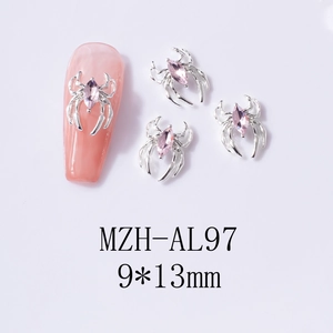 Macro detail of 9x13mm silver spider nail art charms with pink marquise gemstone inlay