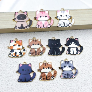 Close-up of ten assorted cat-shaped metal charms with colorful enamel for DIY jewelry