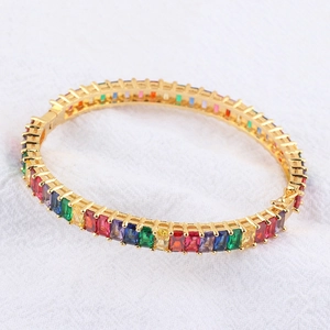 Detail of bohemian gold bangle set with colorful rainbow cubic zirconia and side clasp