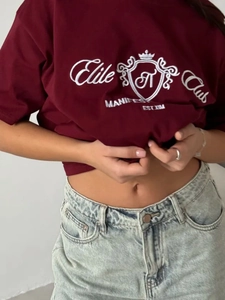 Gros plan sur la broderie blanche du t-shirt en coton bordeaux au style décontracté