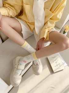Detail of yellow cartoon bear socks paired with Mary Jane shoes on stone steps