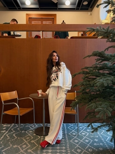 Détail d'un ensemble sweatshirt blanc à motif cirque et pantalon de jogging à rayures