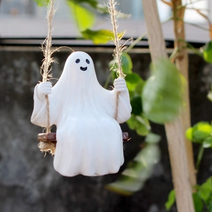 Ghost statue on wooden swing hanging from hemp rope in outdoor garden setting