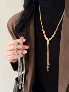 Detailed view of layered tassel necklace in gold and silver finish on a model