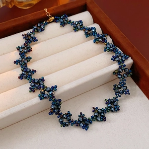 Detailed view of beaded necklace with blue and green beads in a jewelry box