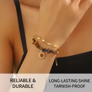 Détail du bracelet double couche avec perles d'oeil de tigre et pendentif soleil au poignet