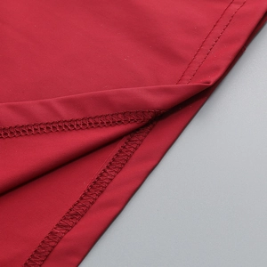 Detail of red stretch fabric showing high-quality double-needle stitching and overlock seams