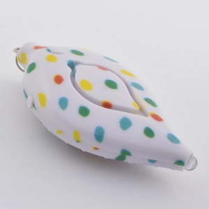Macro view of white leaf-shaped personal alarm with colorful dots and LED indicator