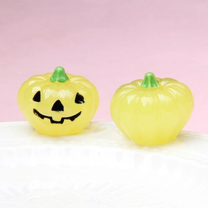 Detailed view of yellow luminous Halloween pumpkins with spooky face on white plate