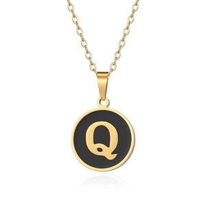 Dettaglio della collana in titanio dorato con pendente circolare nero e oro lettera Q