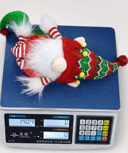 Christmas gnome plush toy weighing 140.4g on a blue scale with red and green sequin details