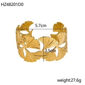 Detailed view of the hollow ginkgo leaf design on a gold-plated open bangle bracelet