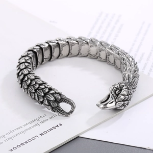 Close-up of punk style eagle head bracelet with detailed feather texture on book