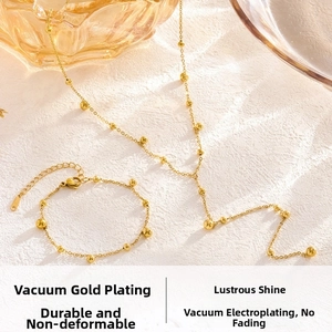 Close-up of golden beaded jewelry set featuring a necklace and bracelet on white marble