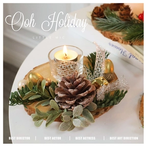 Close-up of a festive Christmas log candle holder with pine cones and golden bells