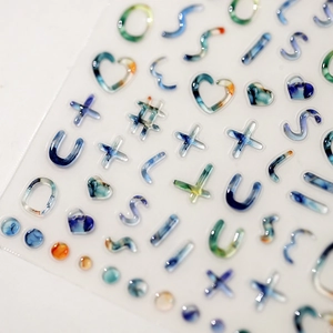 Cute 3D resin nail art stickers with colorful alphabet and heart shapes on white background