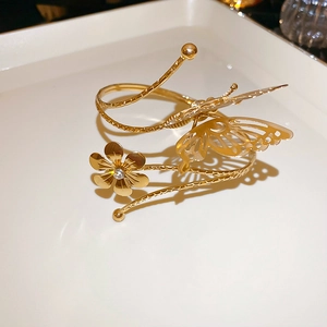 Detail of gold butterfly and flower cuff bracelet with sparkling white rhinestone accent