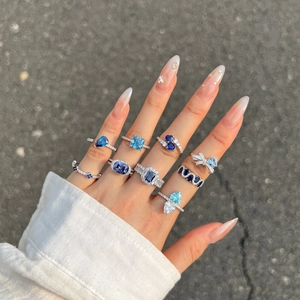 Detailed view of ten silver S925 rings with blue heart-shaped cubic zirconia on hand