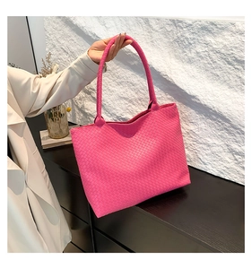 Close-up of magenta woven tote bag featuring high-quality Intrecciato craftsmanship