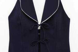 Detail of dark blue halter top with white wavy lace collar and double string ties