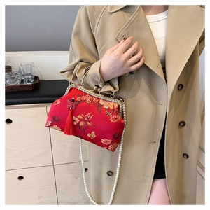 Detail of red floral embroidery and pearl strap on the vintage clasp handbag