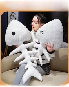 Soft white fish bone plush toy pillow with fuzzy texture held by a model on sofa