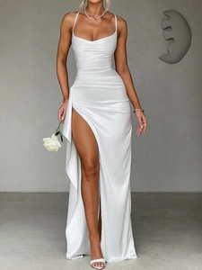 Detail view of white elegant evening dress featuring pleated fabric and a high side slit