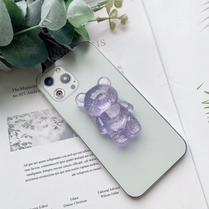Dettaglio ravvicinato di un supporto per telefono a forma di orso glitterato viola brillante