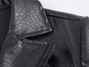 Detailed close-up of black crocodile-embossed faux leather collar and stitching