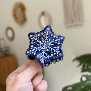 Vue rapprochée d'une pince à cheveux flocon de neige bleu foncé avec des strass brillants