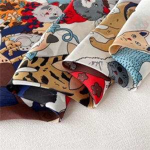 Detailweergave van een lichte vierkante sjaal met kleurrijke katten- en abstracte patronen