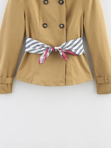 Detail eines khakifarbenen Doppelreiher-Trenchcoats mit gestreiftem Seidenschal-Gürtel