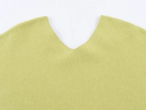 Close-up of a grass green V-neck knit top showing detailed stitching and fabric texture