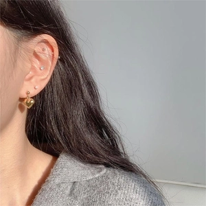 Minimalist 925 sterling silver heart and pearl stud earrings set worn by a female model