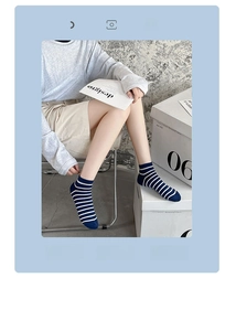 Detail of blue and white striped cotton socks with elastic ribbed cuffs on a model