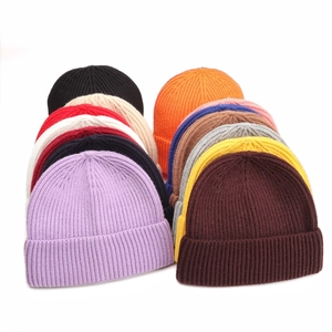 Multiple colors of ribbed knit beanies displayed in an organized stack on a white background