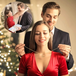 Dettaglio della collana a farfalla dorata indossata su uno sfondo festivo romantico