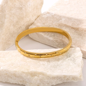 Elegant 18K gold-plated stainless steel star bangle with crystals on a white stone