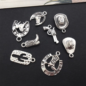 Macro shot of vintage silver alloy western charms including cowboy hat and cactus designs