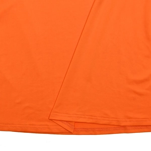 Détail de l'ourlet à double aiguille et tissu mesh orange sur une robe maxi sexy
