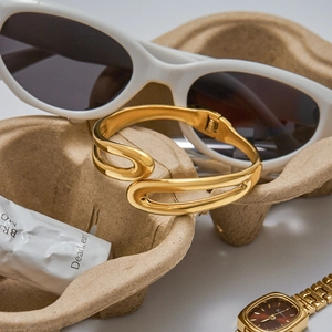Close-up of a 18K gold-plated double-layered spring bangle in a luxury lifestyle setup