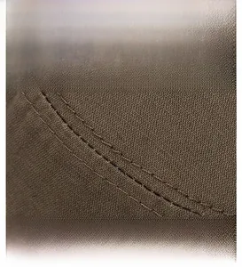 Detailaufnahme von braunem Baumwollstoff mit präziser Doppelnaht am Rand der Schirmmütze