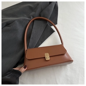 Detailed view of brown PU leather bag with vintage metal twist lock and long shoulder strap